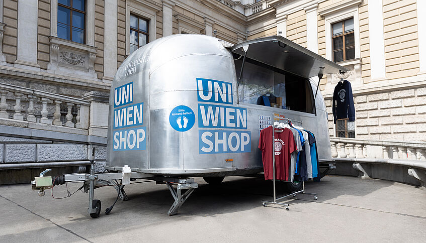 Silberner Wohnwagen-Shop vor dem Hauptgebäude der Universität Wien